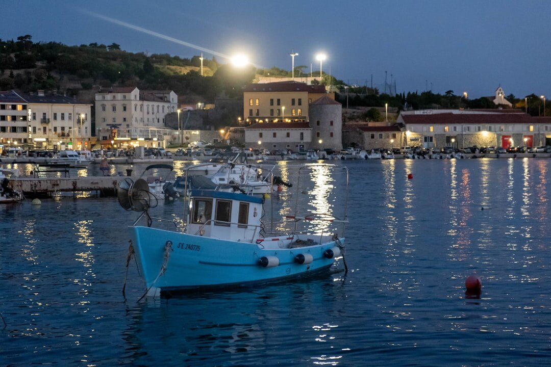Quiet moonlit harbor with small fishing boats along the Adriatic coast