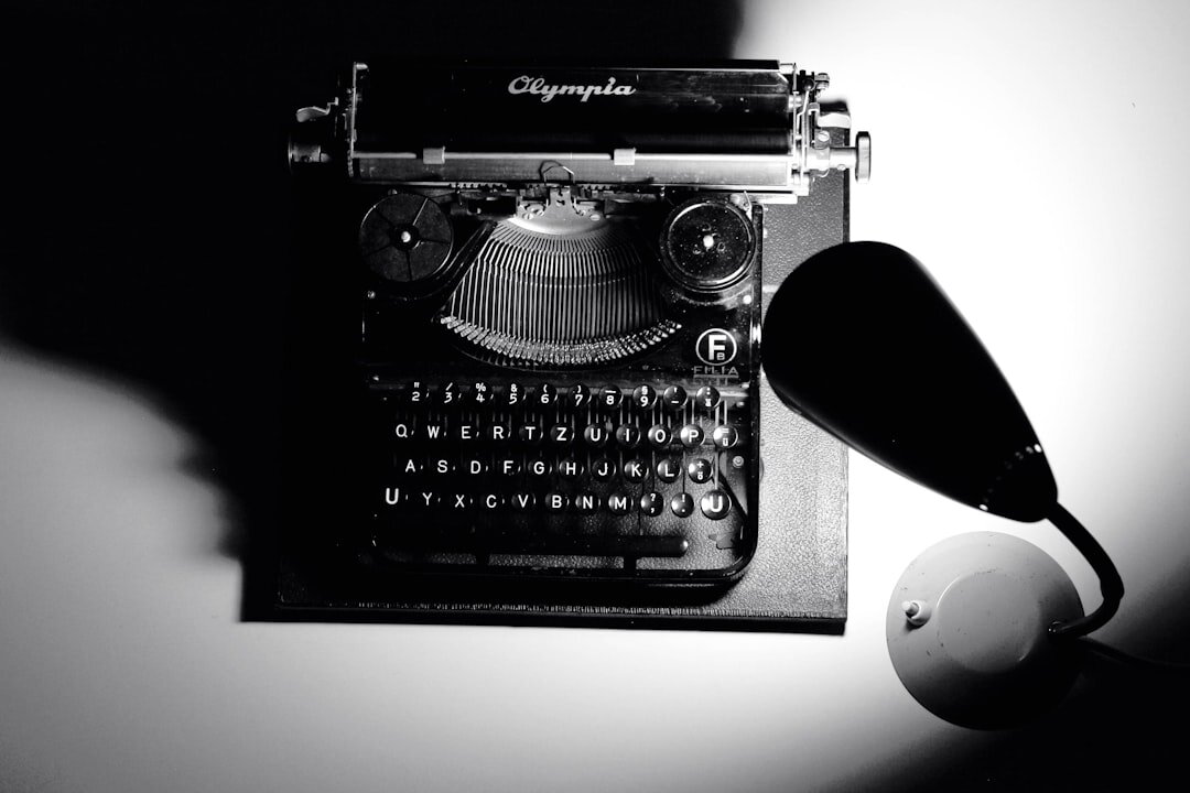 Vintage typewriter with crumpled paper and a magnifying glass on a wooden desk